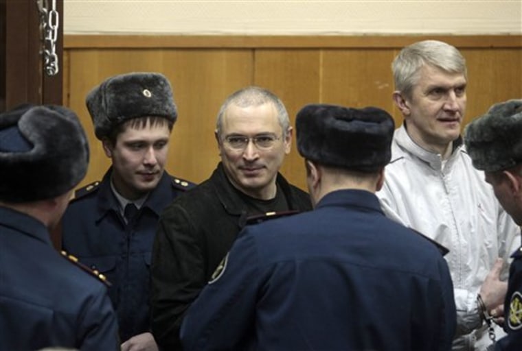 Mikhail Khodorkovsky, center, and his co-defendant Platon Lebedev, right, are escorted to a court room in Moscow, Russia, Monday, Dec. 27, 2010. The judge on Monday declared former oil tycoon Mikhail Khodorkovsky guilty of theft and money laundering charges in his second trial, Russian news agencies reported, a verdict that would likely keep Russia's once richest man behind bars for several more years. (AP Photo/Sergey Ponomarev)